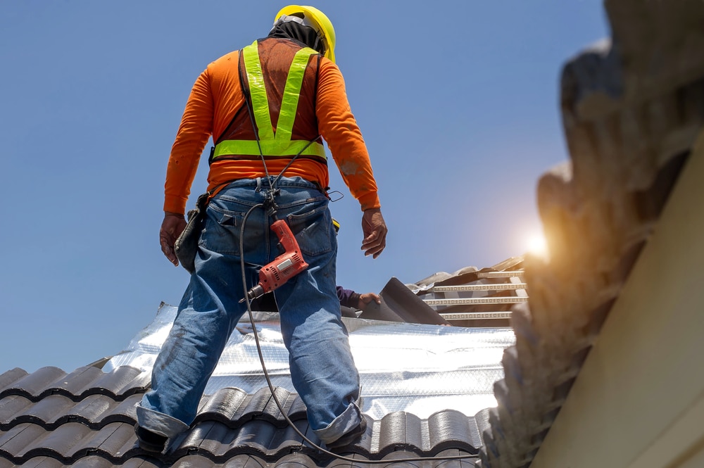 A construction worker building a new roof after learning 8 things to know before installing a new roof.