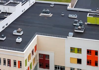 Top view dark flat roof with air conditioners and hydro insulation membranes modern apartment building residential area.